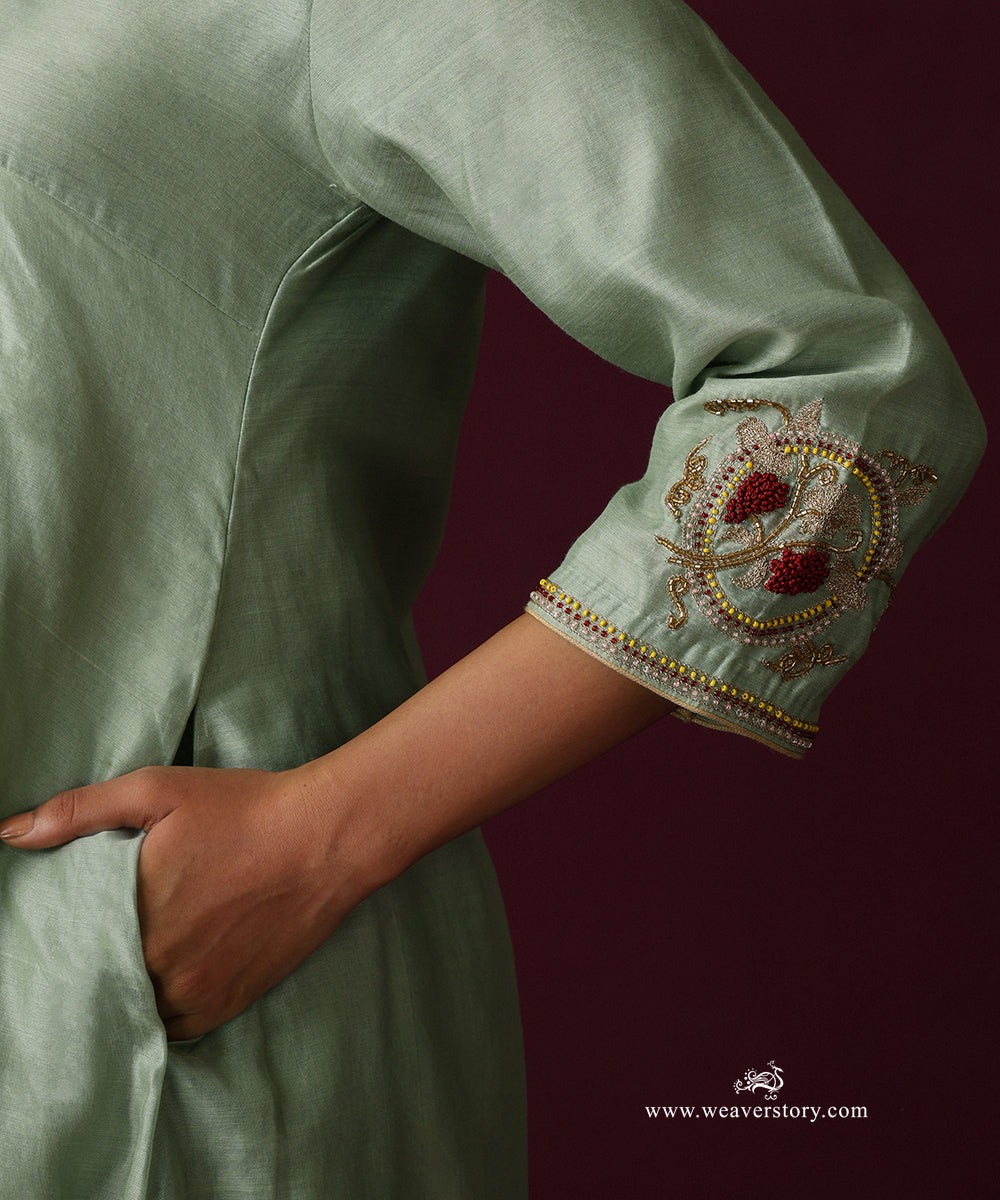 Detail of the embroidered floral vine motif and decorative edging on the sage green kurta cuff