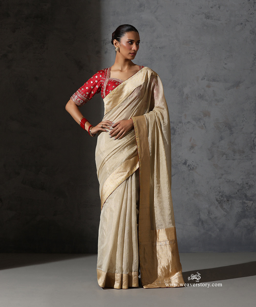 Full-length front view of Mridula ivory-gold pure cotton tissue saree with vintage Banarasi zari border and red contrast blouse.