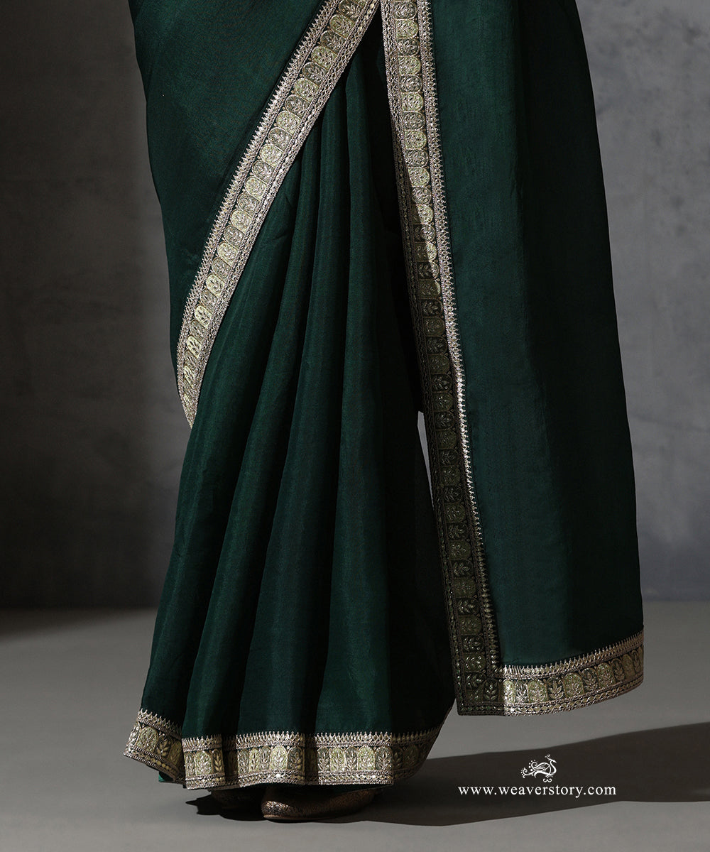 Detail of Nandini bottle green organza silk saree showing the resham and zari embroidered motifs and fine edging.