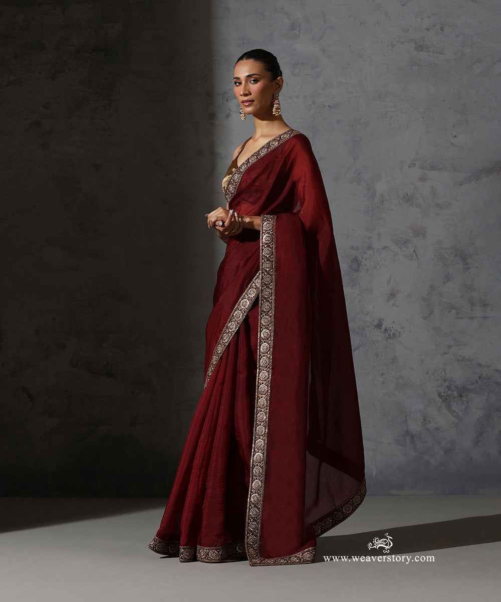 Front view of Ragini maroon handwoven pure silk organza saree styled with a gold blouse, highlighting the floral zardozi and resham embroidered border.