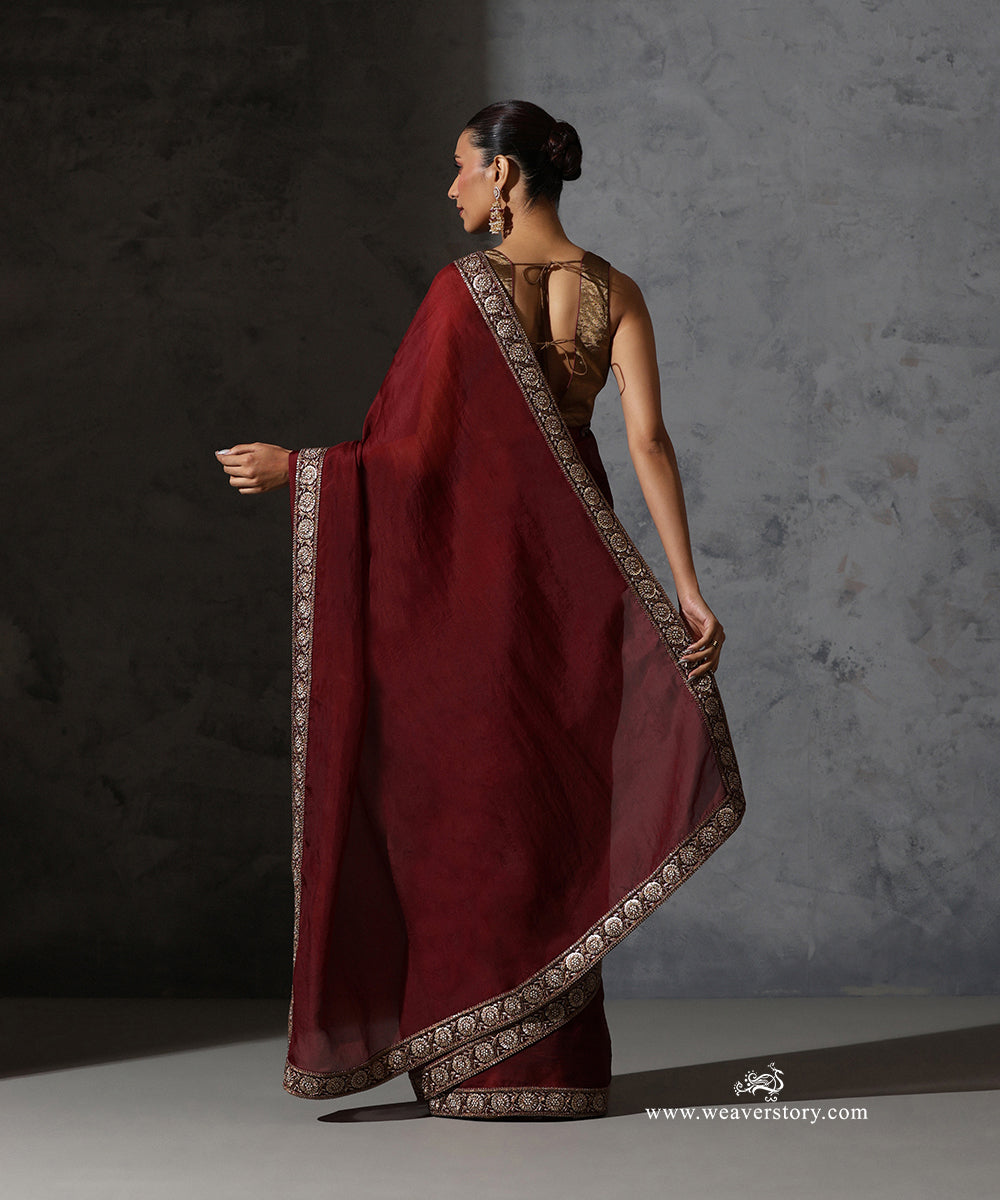 Back view of Ragini maroon handwoven pure silk organza saree showing the plain translucent body and embroidered floral border.