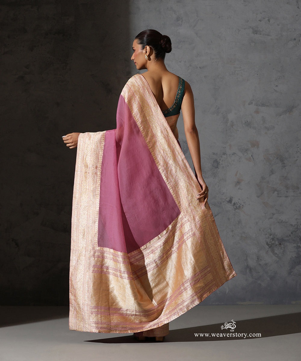 Back view of Mrignayani light pink organza saree highlighting the sheer body, broad vintage Banarasi zari border and richly woven pallu.
