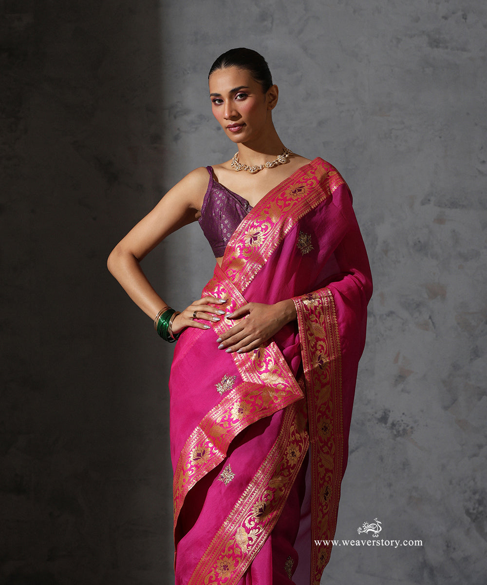 Front view of Madhulika hot pink organza saree highlighting the zardozi meenakari bootis and Banarasi border with floral, bird and paisley motifs.