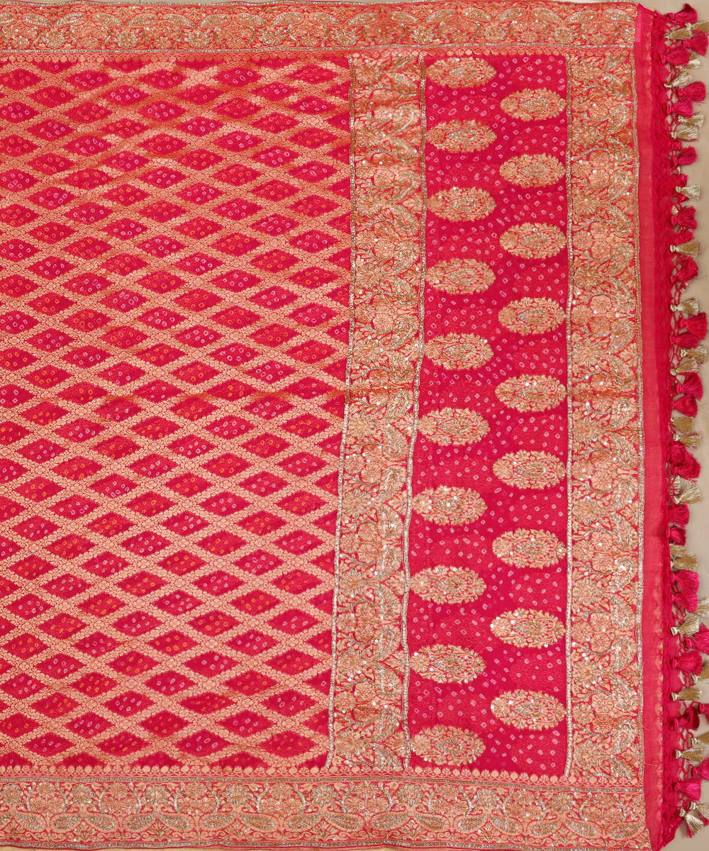 Full view of hot pink Banarasi Bandhani dupatta with a zari lattice body, broad paisley palla, zardozi highlights and tasselled edging.