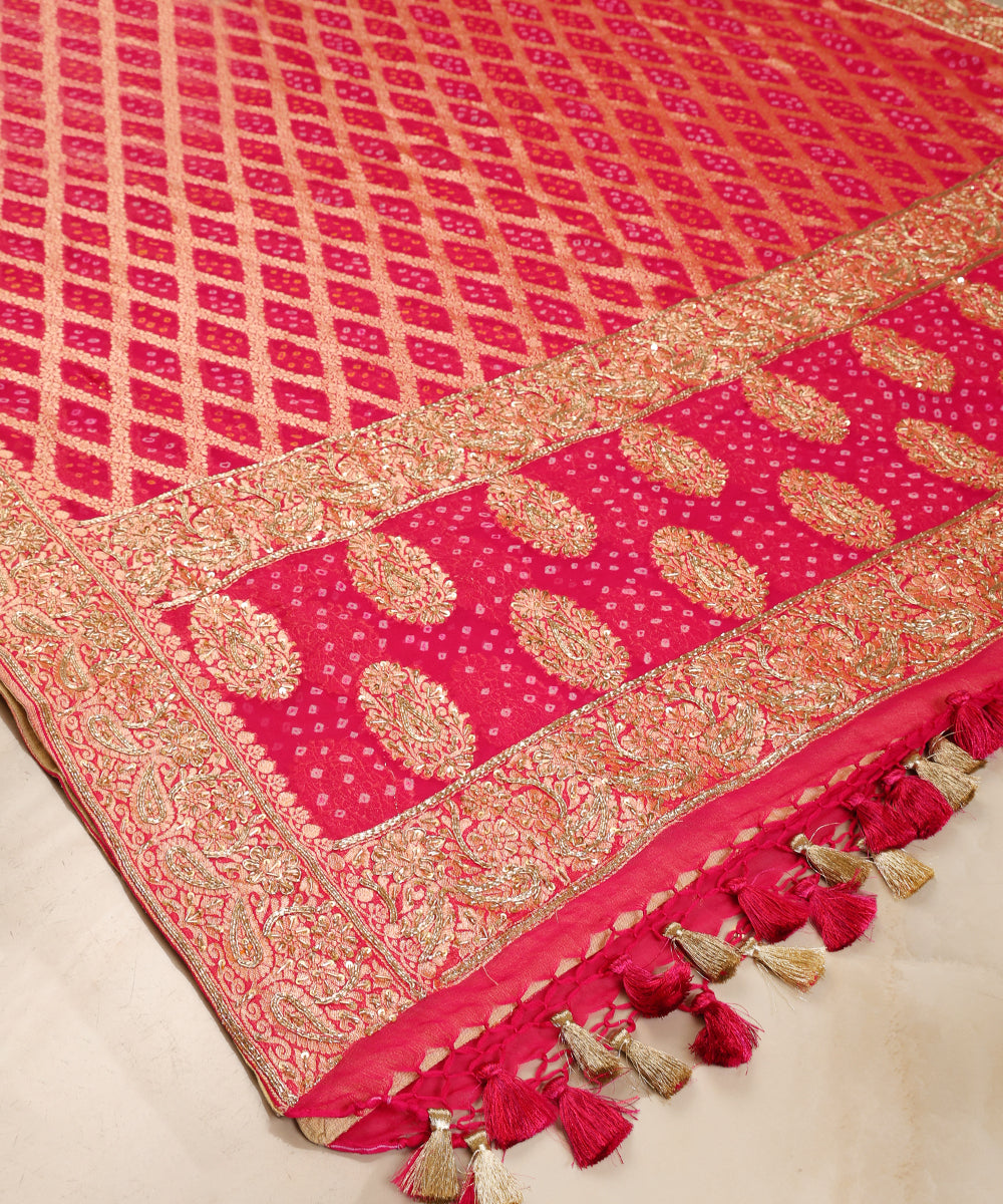 Detailed view of hot pink Bandhani dupatta featuring a cutwork lattice, Bandhej dots, embroidered paisley panels and floral borders.
