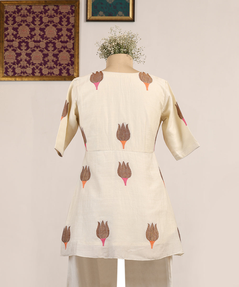 Beige kurta with floral patterns on a mannequin against a light background