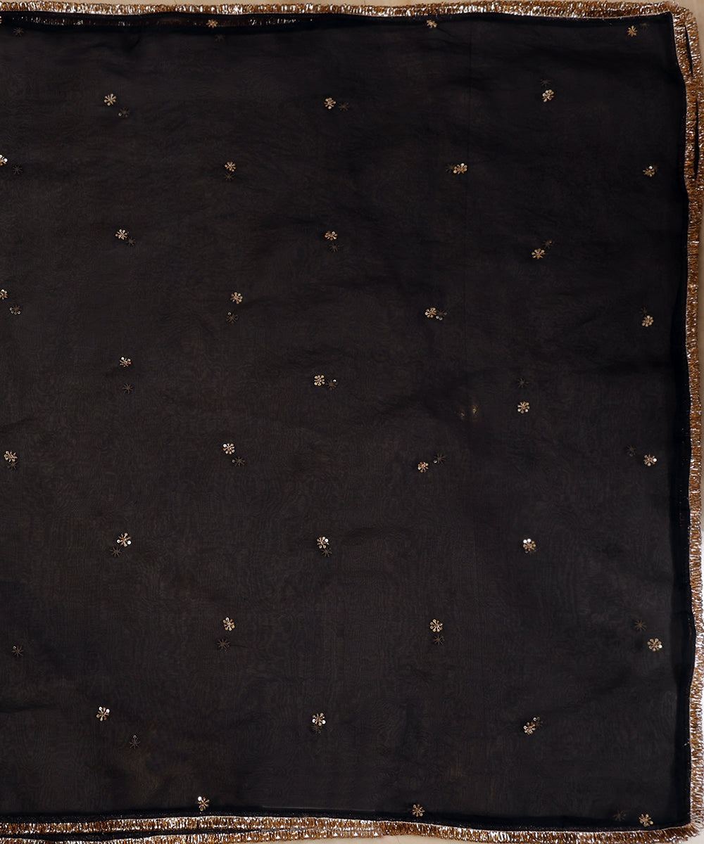 Full view of black organza dupatta with delicate gold zardozi bootis placed across the sheer surface.