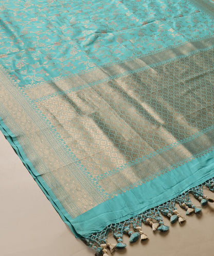 Light turquoise Katan silk Jangla dupatta with small zari roses, trailing floral vines, geometric zari palla and knotted tassels.