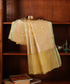 Lemon handloom Kora tissue dupatta draped over a wooden cabinet, showing its luminous patterned weave, sheer section and pale-green edging.