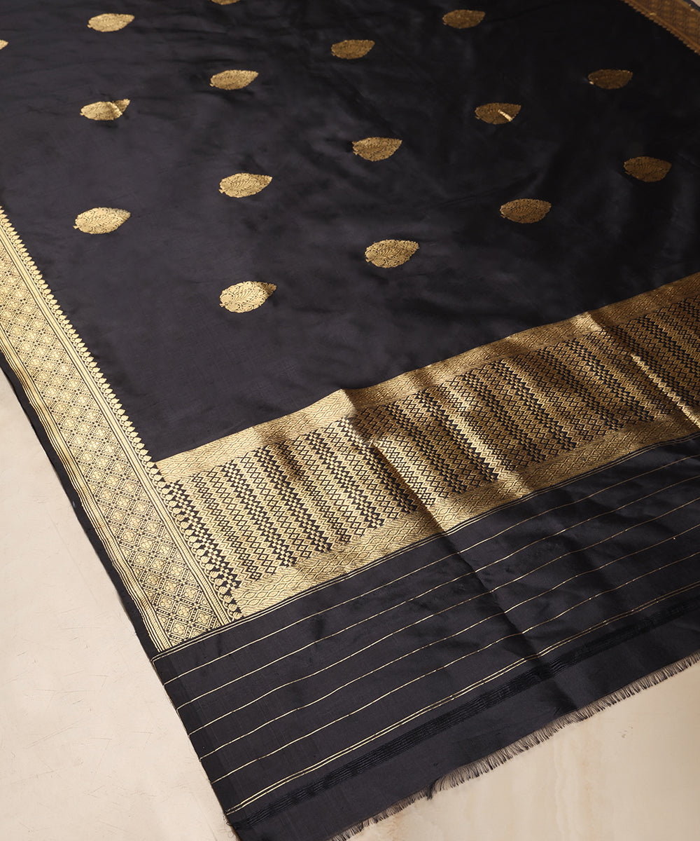 Close-up of black pure Katan silk Banarasi dupatta with gold zari leaf bootis, geometric border and intricately patterned palla.