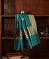 Green pure Katan silk Kadhwa dupatta displayed against a wooden cabinet, showing gold zari bootis, floral borders and fine palla stripes.