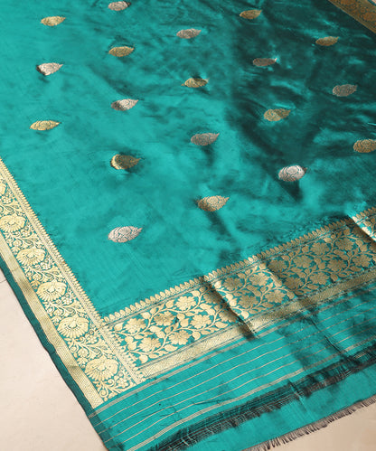 Close-up of green pure Katan silk Banarasi dupatta with gold zari leaf bootis, floral Kadhwa border and striped palla.