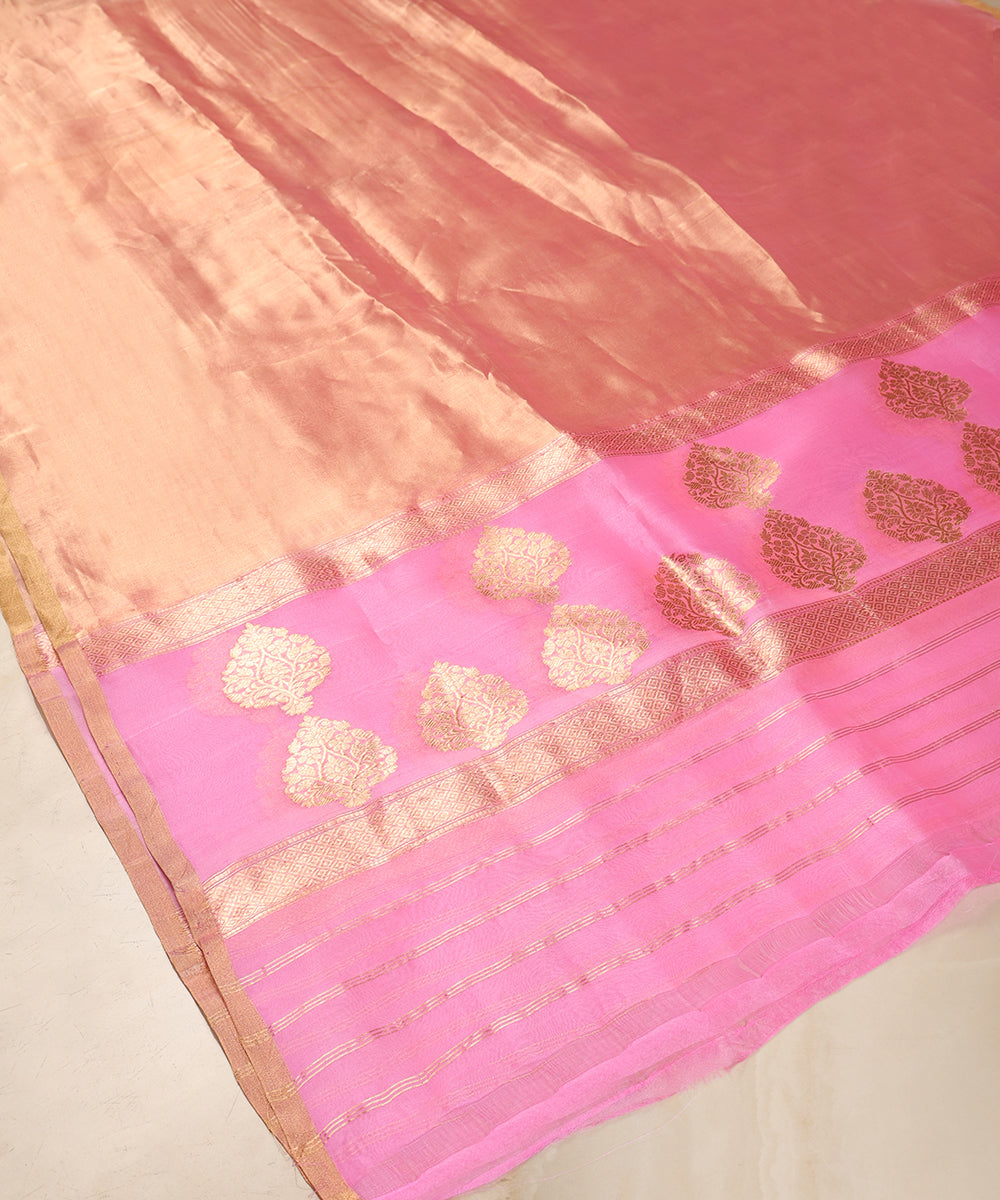Pink and gold Banarasi Kora tissue dupatta displayed against a wooden cabinet, showing floral bootas, zari stripes and sheer texture.
