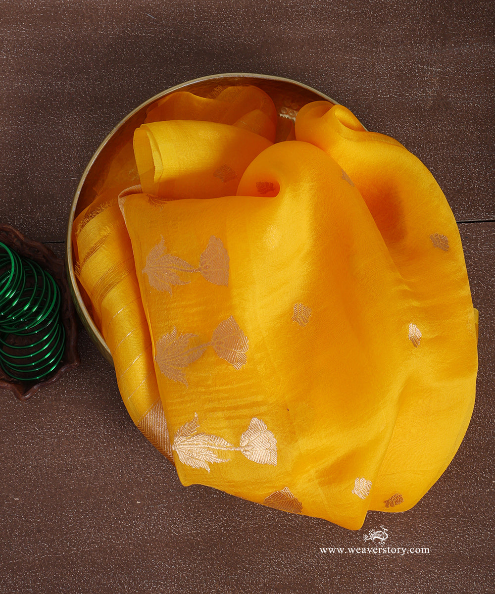 Mustard yellow pure silk organza Banarasi dupatta with small gold-toned floral bootis and larger lotus motifs with leafy stems.