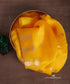 Mustard yellow pure silk organza Banarasi dupatta with small gold-toned floral bootis and larger lotus motifs with leafy stems.