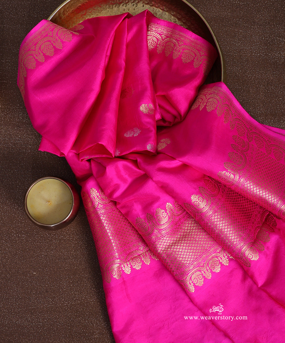 Close-up of gold-toned Kadhwa floral bootis and a floral vine border on a rani pink handloom pure Katan silk dupatta.