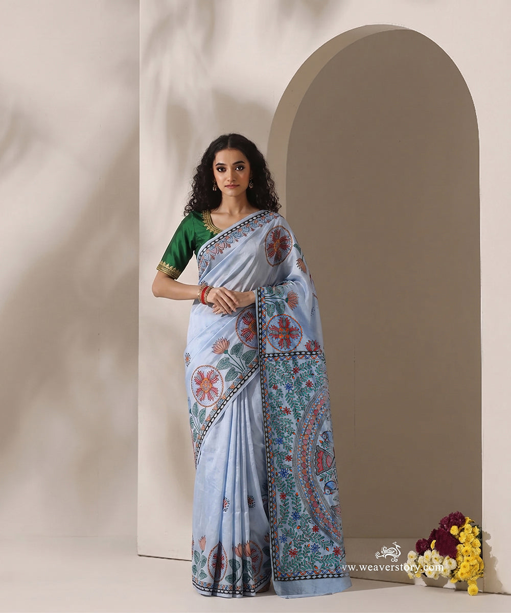 Model wearing a sky blue handloom Chanderi saree with a mandala-style Madhubani pallu and circular fish borders.