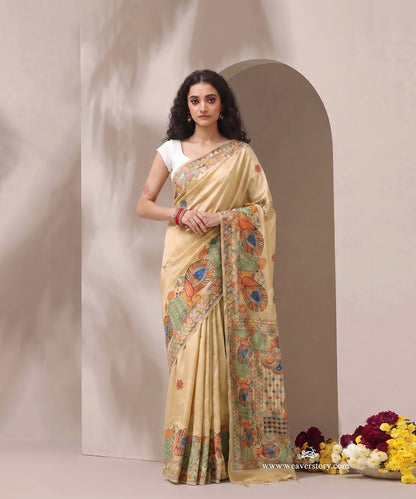 Model wearing a beige gold handloom Chanderi Madhubani saree with intricate painted bird borders.