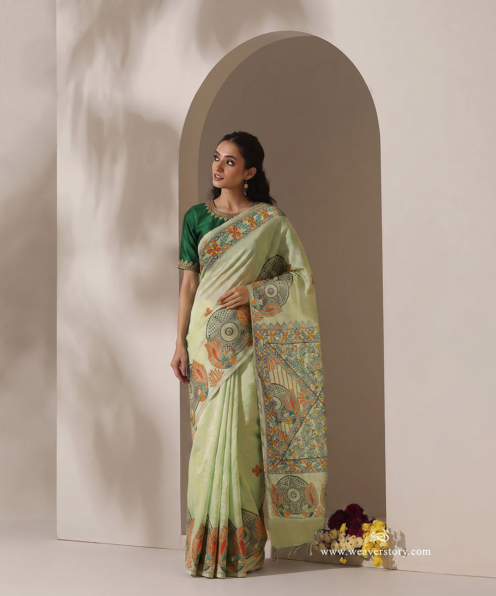 Pastel green handloom Chanderi with a painted border of red-and-yellow flowers, green leaves and small coloured triangles.