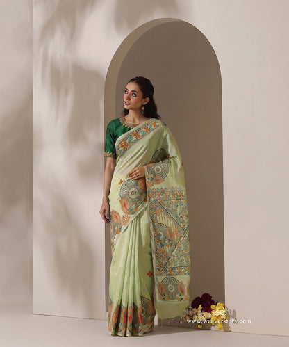 Pastel green handloom Chanderi with a painted border of red-and-yellow flowers, green leaves and small coloured triangles.