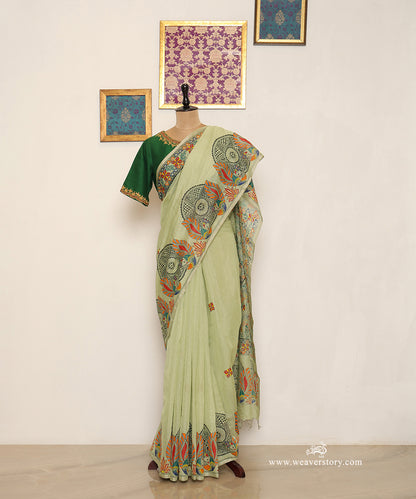 Pastel green handloom Chanderi saree with hand-painted Madhubani birds along the border and small flowers across the body.