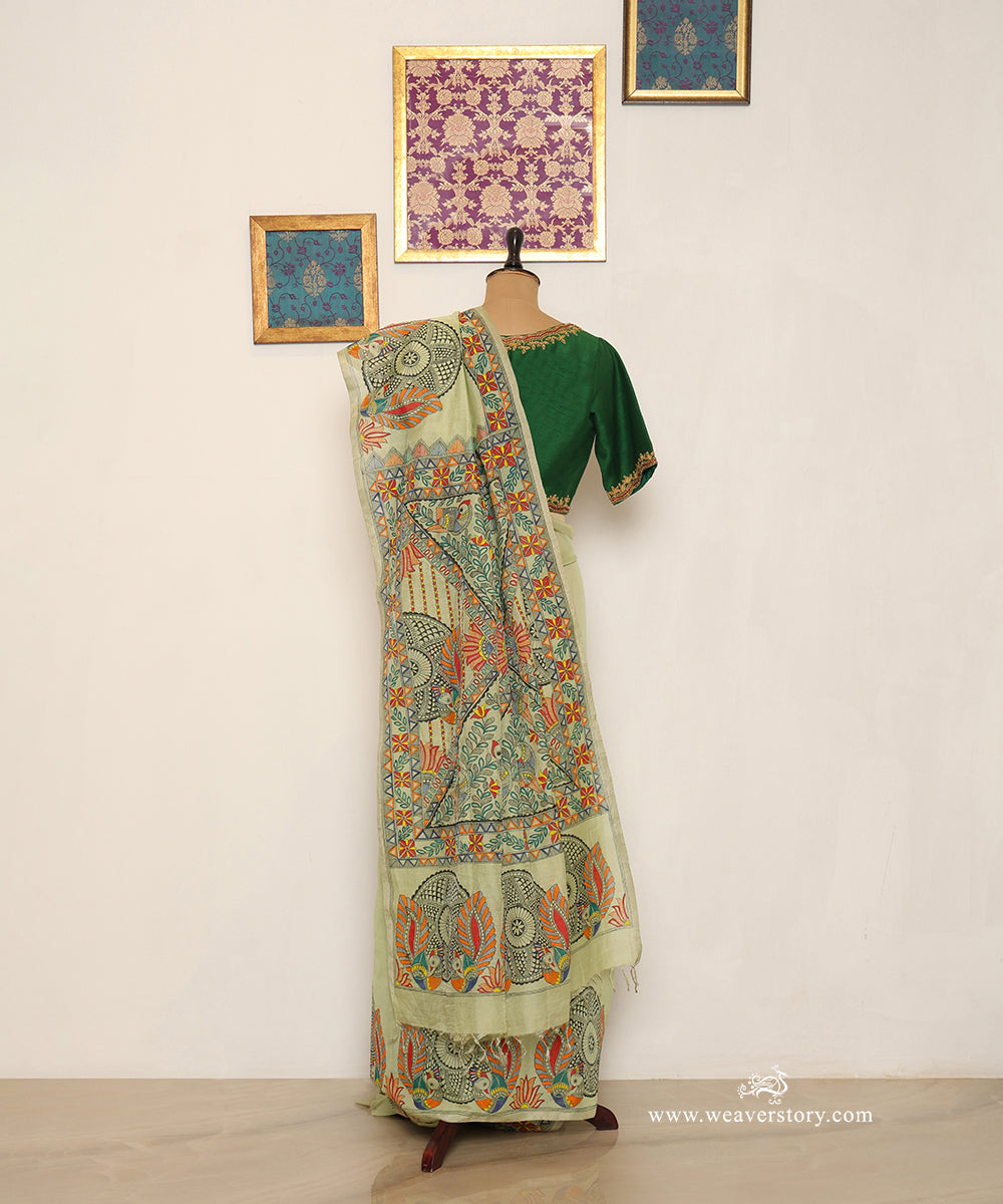 shoulder drape showing paired Madhubani birds and round floral patterns painted on a pastel green Chanderi saree.