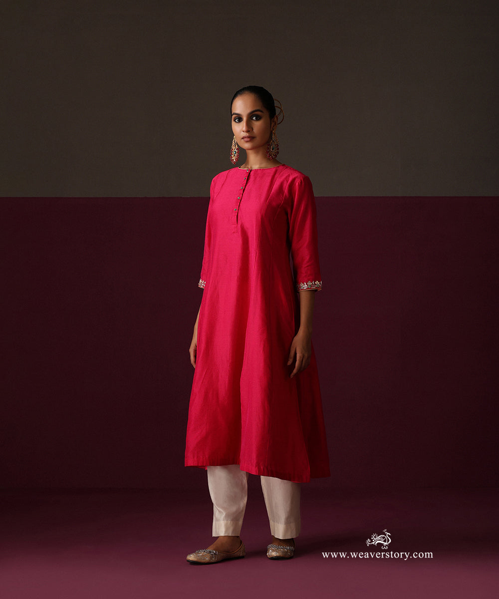 Front view of the hot pink gently flared Chanderi kurta with embroidered cuffs and ivory pants