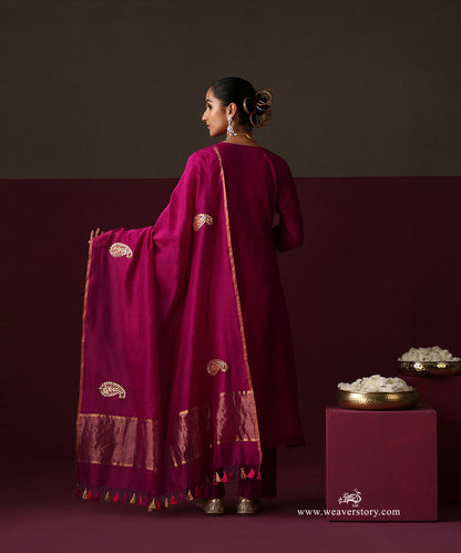 Detail of the deep magenta dupatta’s striped gold border and tassels with matching straight pants