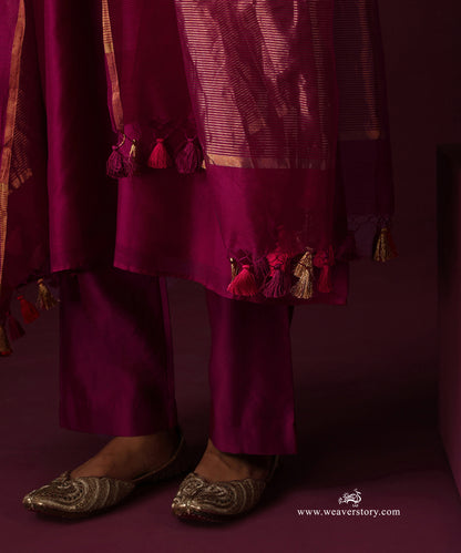 Detail of the deep magenta dupatta’s striped gold border and tassels with matching straight pants
