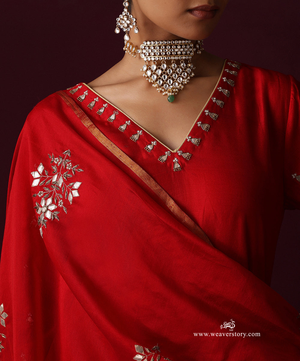 Close-up of the red kurta’s embroidered V neckline and a floral motif on the dupatta