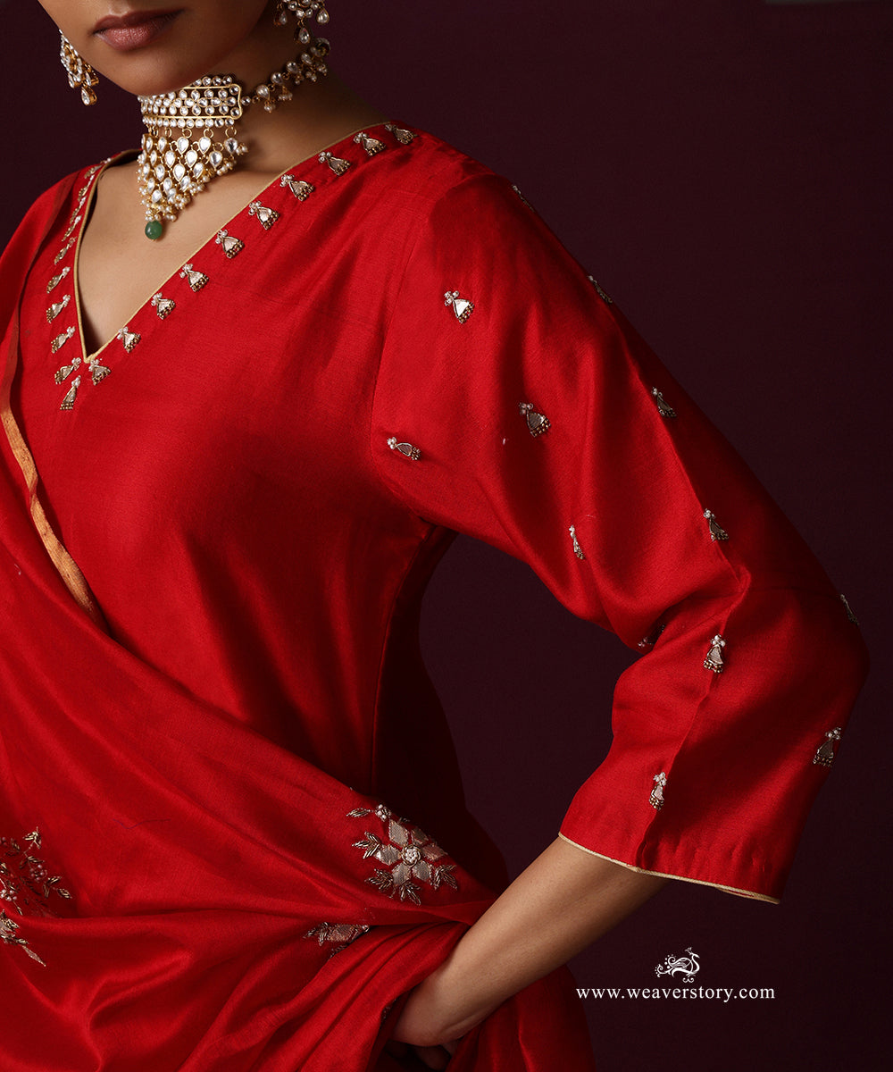 Close-up of the red kurta’s embroidered V neckline and a floral motif on the dupatta