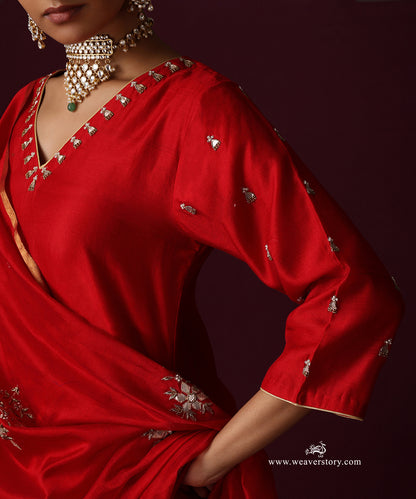 Close-up of the red kurta’s embroidered V neckline and a floral motif on the dupatta