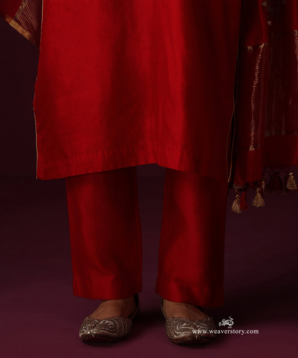 Detail of the blood red straight kurta hem, matching pants and dupatta tassels