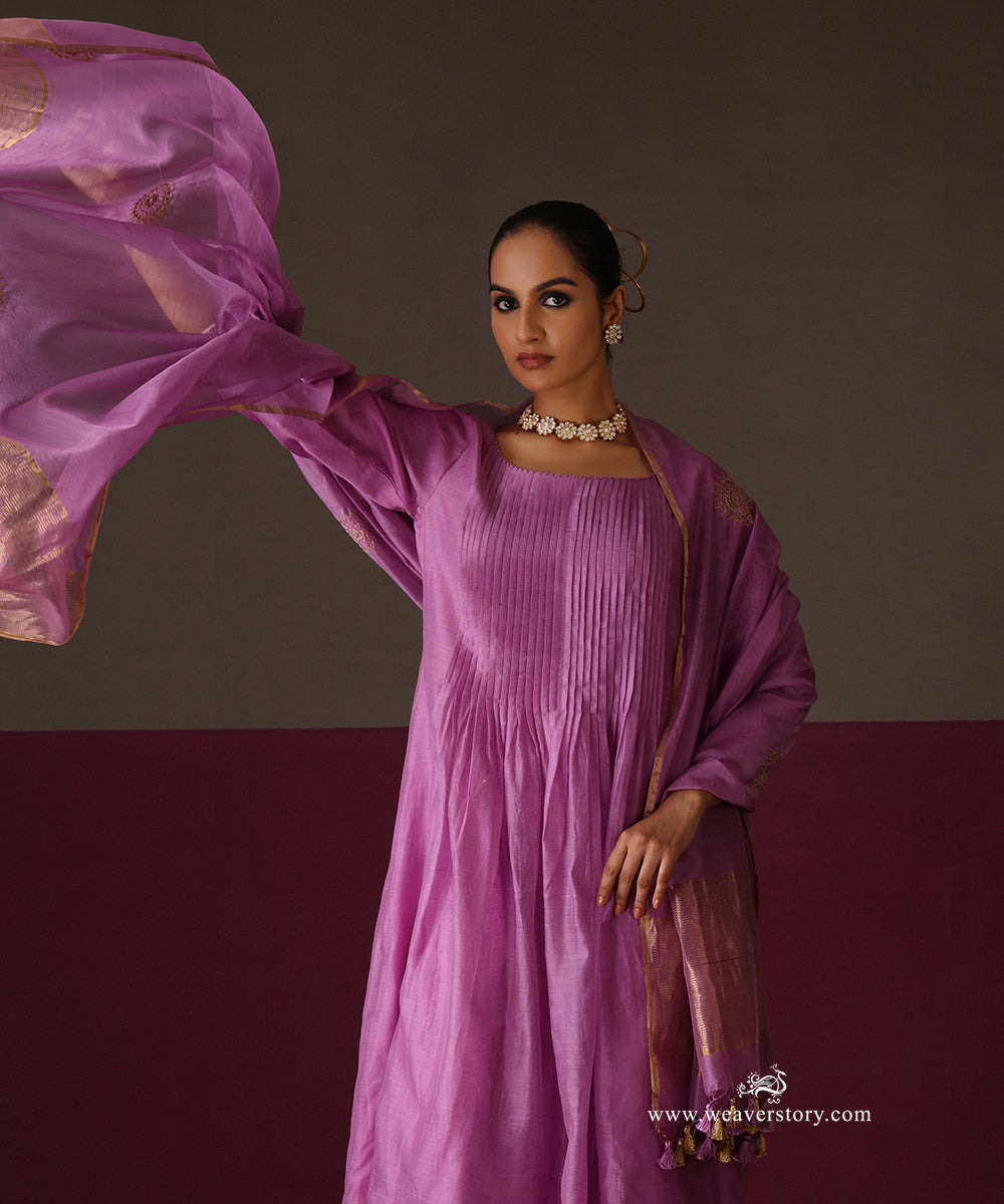 Model holding the orchid purple dupatta to show its gold tissue borders and tassels