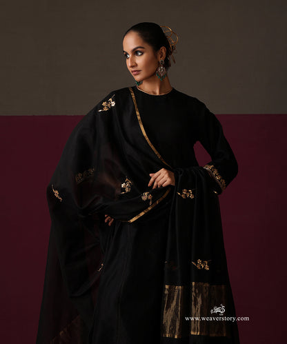 Model wearing Nayab, a black Chanderi suit with floral embroidered dupatta and striped gold border