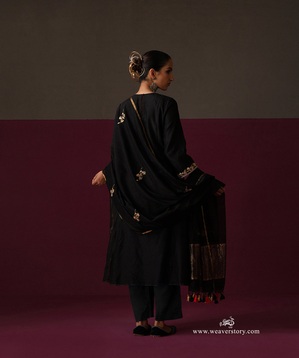 Back view of the black suit with scattered floral motifs on the dupatta and a striped gold border