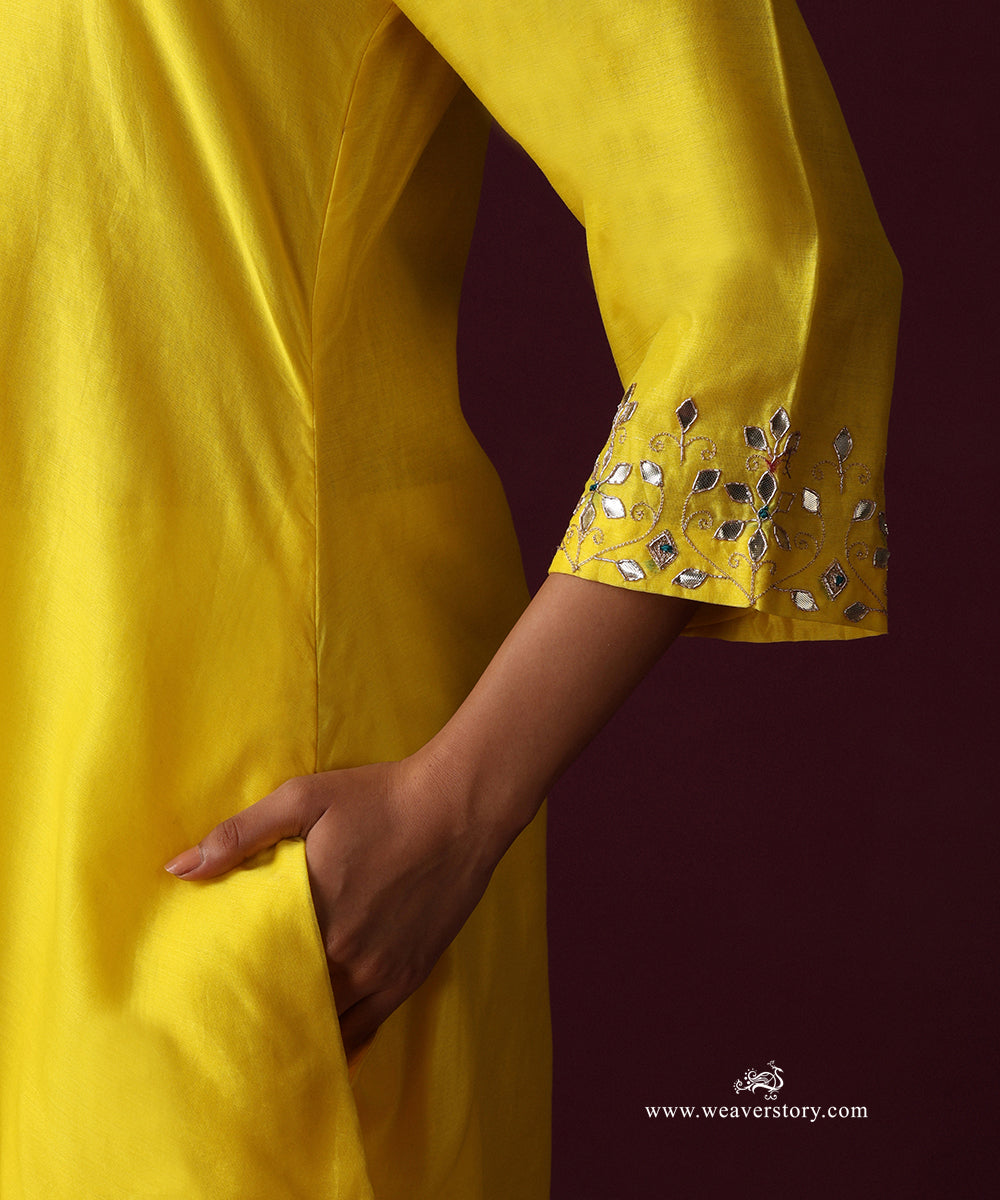 Close-up of floral gota patti and zardozi hand embroidery on the yellow kurta cuff