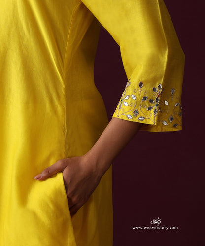 Close-up of floral gota patti and zardozi hand embroidery on the yellow kurta cuff