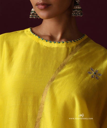 Close-up of the yellow kurta’s rounded neckline with turquoise accents and a floral motif on the dupatta