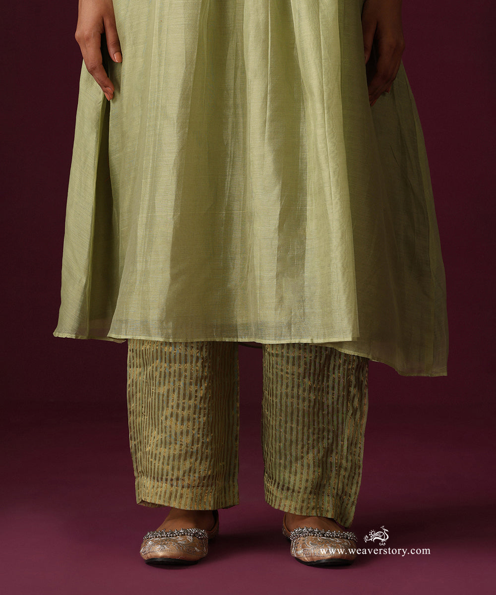Detail of the softly flared kurta hem and pista green striped Chanderi tissue pants