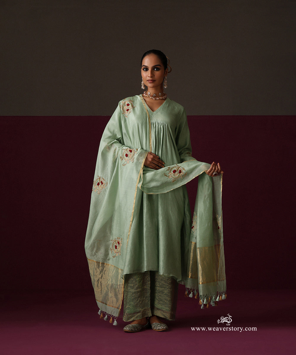 Model wearing Sahar, a sage green gathered Chanderi suit with embroidered dupatta and striped Chanderi tissue pants