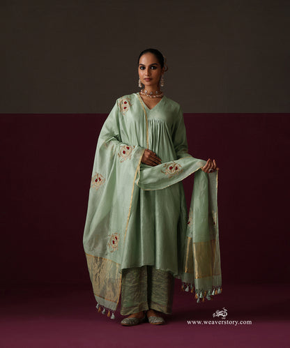 Model wearing Sahar, a sage green gathered Chanderi suit with embroidered dupatta and striped Chanderi tissue pants