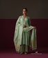 Model wearing Sahar, a sage green gathered Chanderi suit with embroidered dupatta and striped Chanderi tissue pants