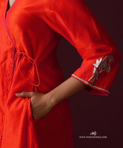 Detail of the orange Angrakha’s pink piping and gota patti lotus embroidery at the cuff