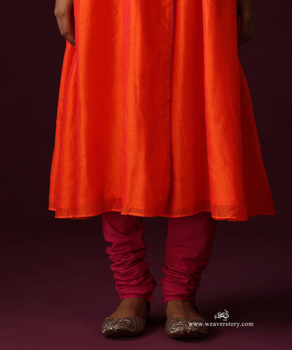 Close-up of the orange flared kurta hem and contrasting hot pink churidar