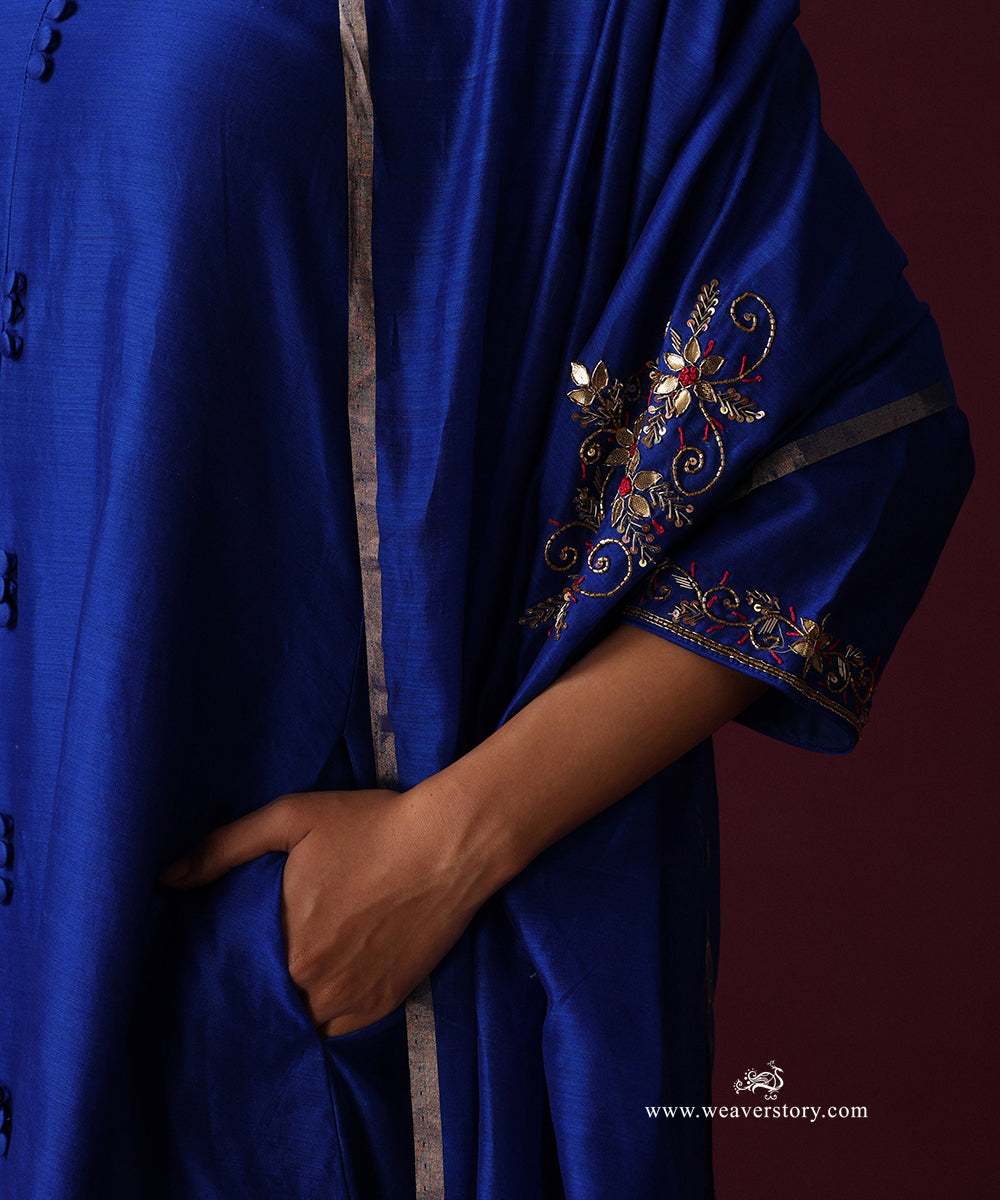 Close-up of the royal blue kurta’s fabric-covered buttons and embroidered sleeve cuff