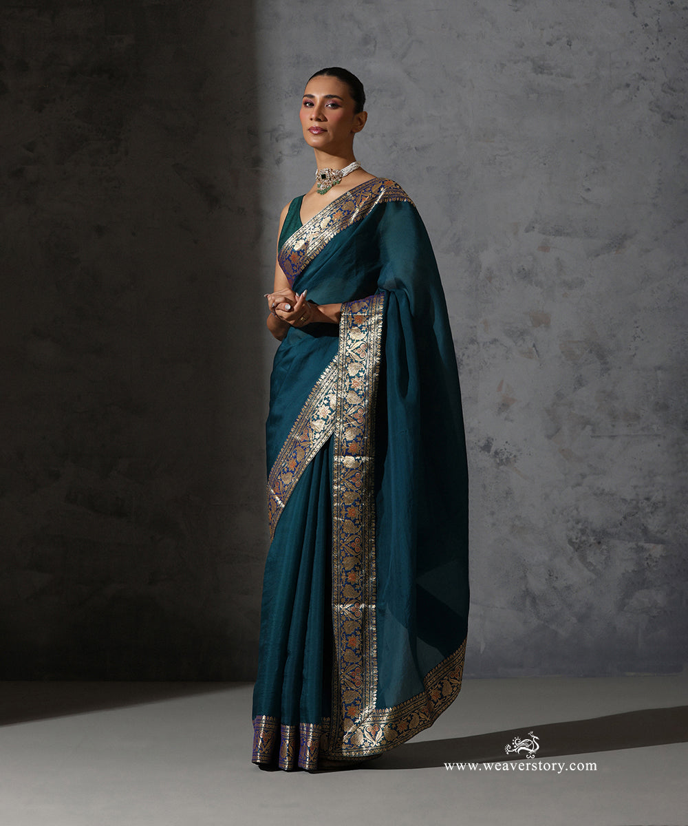 Close view of Madhavi peacock blue organza saree showing the vintage Banarasi zari border with paisley, floral and meenakari detailing.