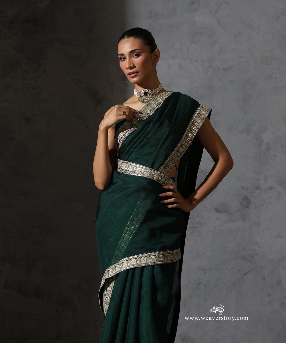 Nandini bottle green organza silk saree with resham and zari embroidered ornamental border.