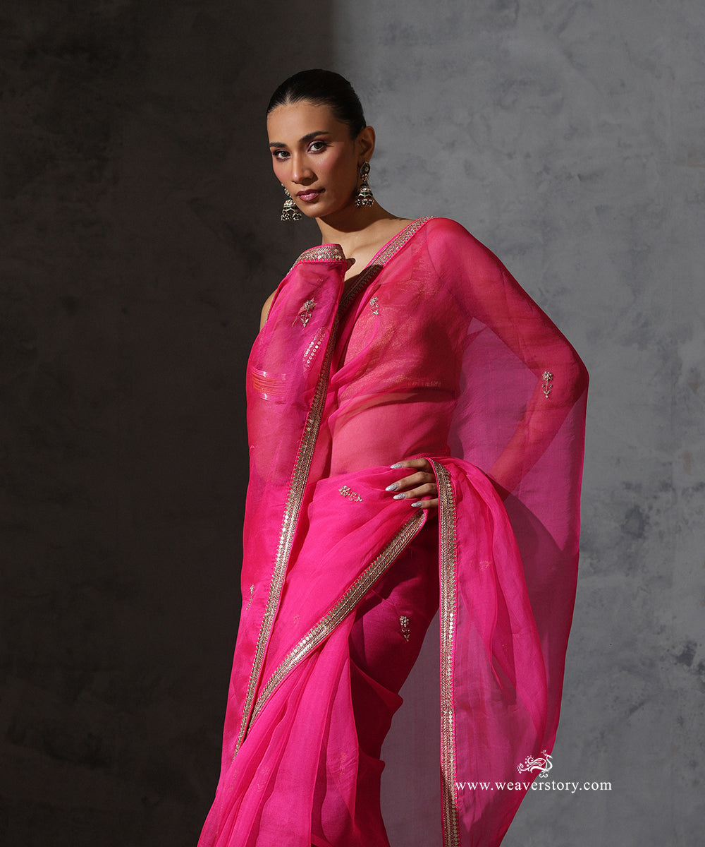 Front detail of Tarini hot pink organza saree highlighting the sheer drape, petite zardozi bootis and narrow hand-embroidered border.