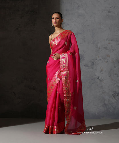 Draped view of hot pink organza saree highlighting the vintage sona zari Banarasi border with floral and purple meenakari details.